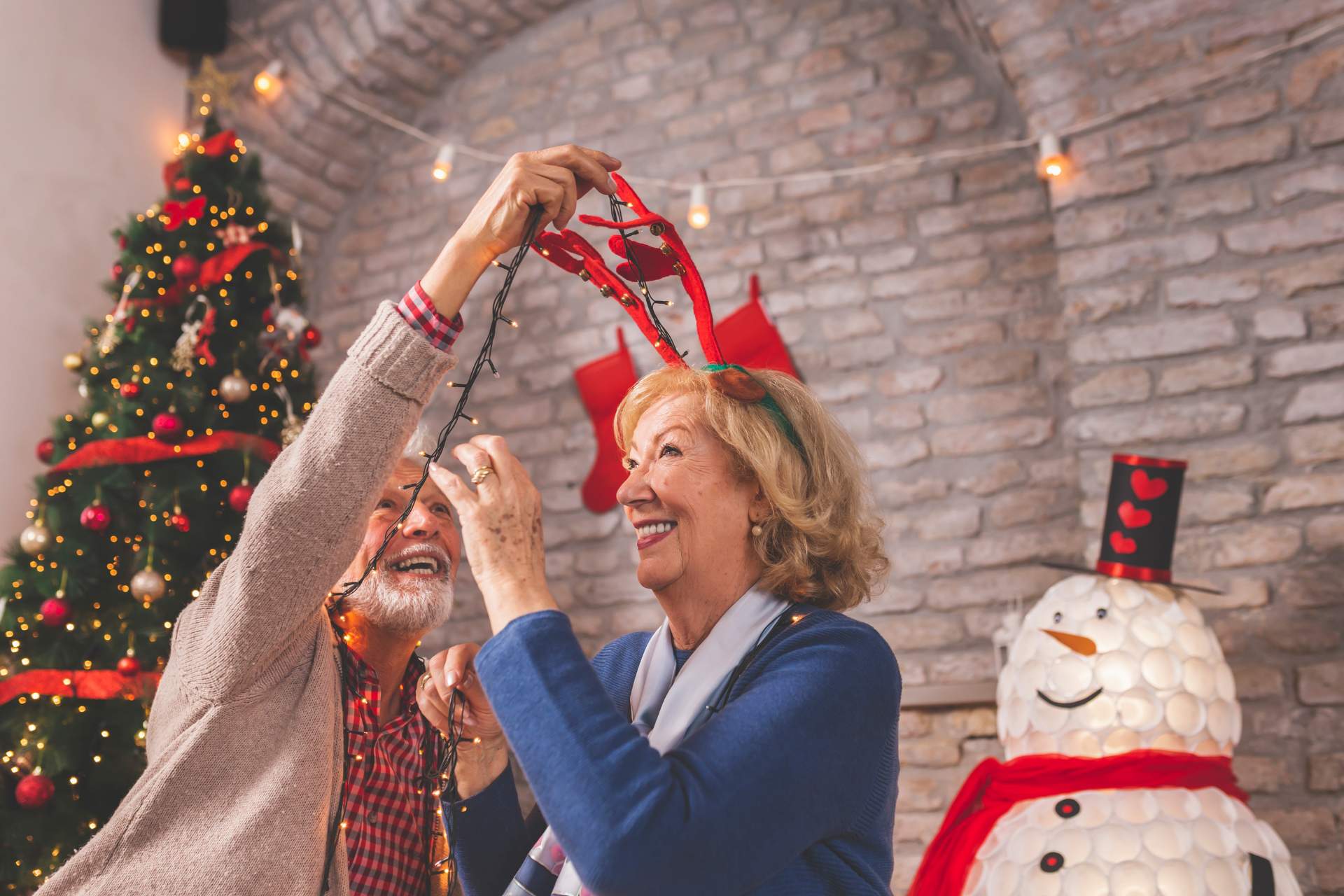 A senior couple decorating for Christmas together.